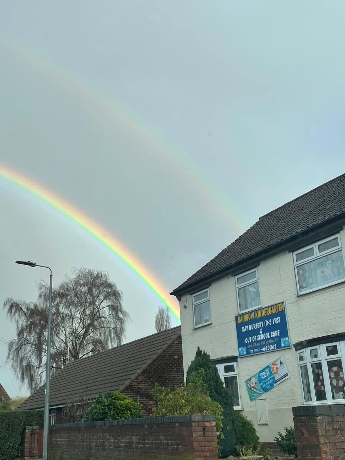 The Rainbow Kindergarten building in Barton-upon-Humber under a double rainbow, with the nursery's day nursery and out-of-school care sign.